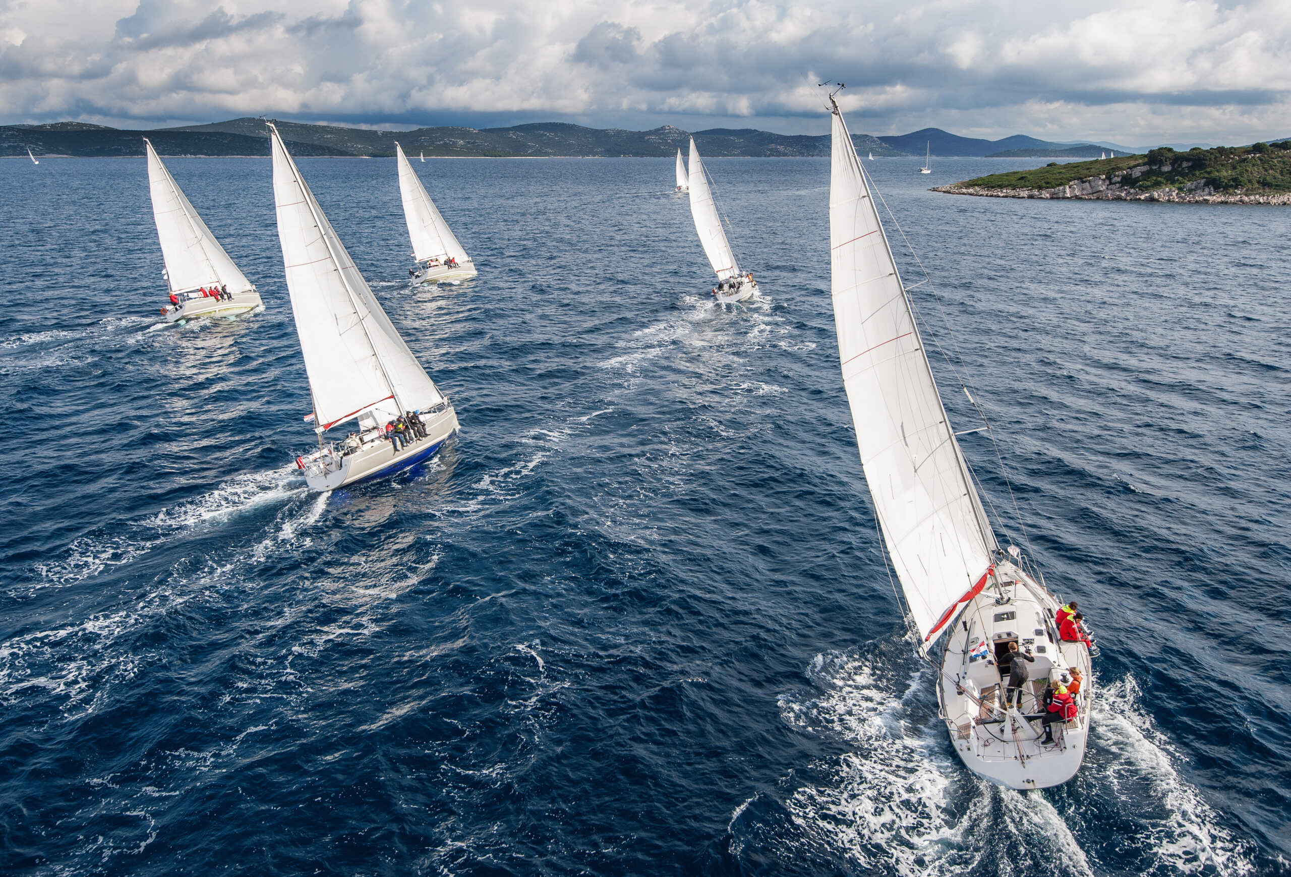 Fleet of sailing boats during offshore race from bird view